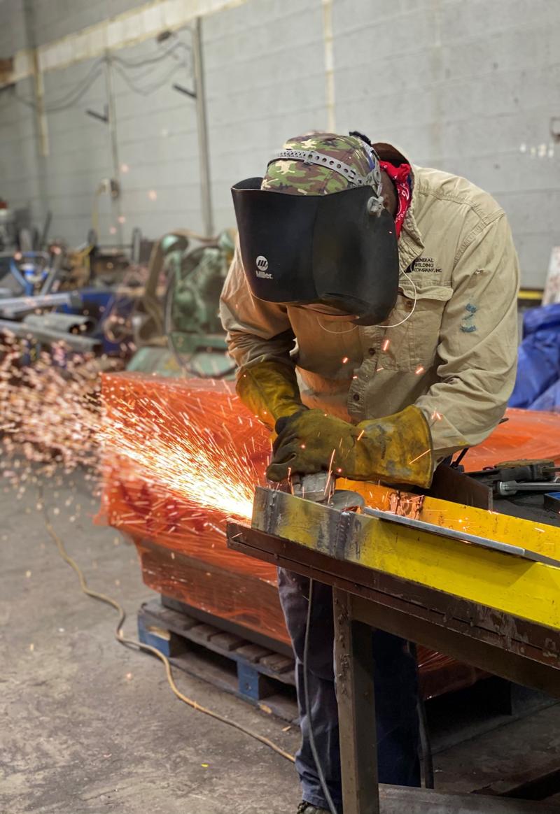 GWC fabricator grinding steel with sparks flying